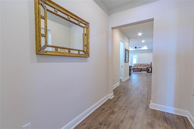 hallway featuring baseboards and wood finished floors