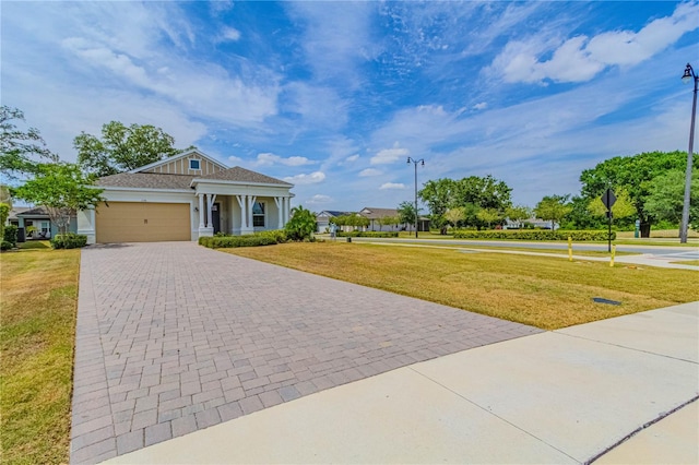 view of front of property with a front lawn, a garage, a shingled roof, stucco siding, and decorative driveway