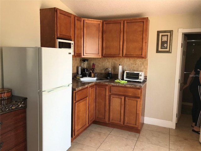 4251 Anthony Ln, Orlando, FL 32822 - kitchen featuring dark countertops, brown cabinetry, a sink, and white appliances