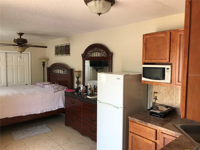 4251 Anthony Ln, Orlando, FL 32822 - bedroom featuring light tile patterned floors, a sink, a textured ceiling, and freestanding refrigerator