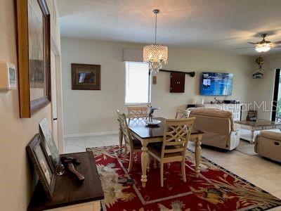 5060 Arancia Ln, Ave Maria, FL 34142 - dining space featuring baseboards, ceiling fan with notable chandelier, and light tile patterned flooring