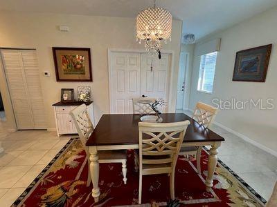 5060 Arancia Ln, Ave Maria, FL 34142 - tiled dining room with a notable chandelier and baseboards