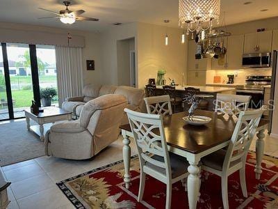 5060 Arancia Ln, Ave Maria, FL 34142 - dining area with ceiling fan with notable chandelier and light tile patterned flooring