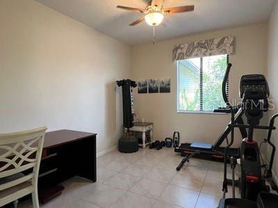5060 Arancia Ln, Ave Maria, FL 34142 - workout room with light tile patterned floors, a ceiling fan, and baseboards