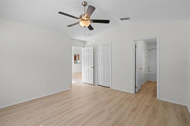 11460 Brown Quail Ct, Orlando, FL 32817 - unfurnished bedroom with light wood-style floors, lofted ceiling, baseboards, ensuite bath, and a closet
