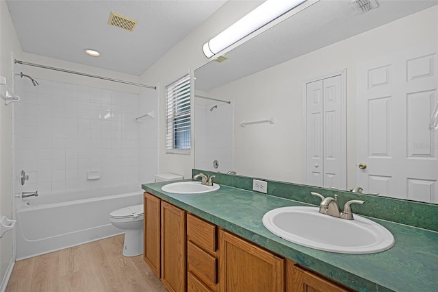 11460 Brown Quail Ct, Orlando, FL 32817 - bathroom with wood finished floors, toilet, shower / bathtub combination, double vanity, and recessed lighting
