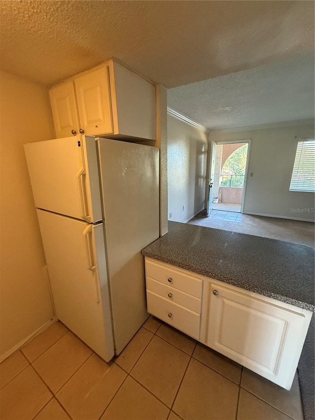128 Water Front Way Unit 300, Altamonte Springs, FL 32701 - kitchen with crown molding, freestanding refrigerator, dark countertops, a textured ceiling, and light tile patterned floors