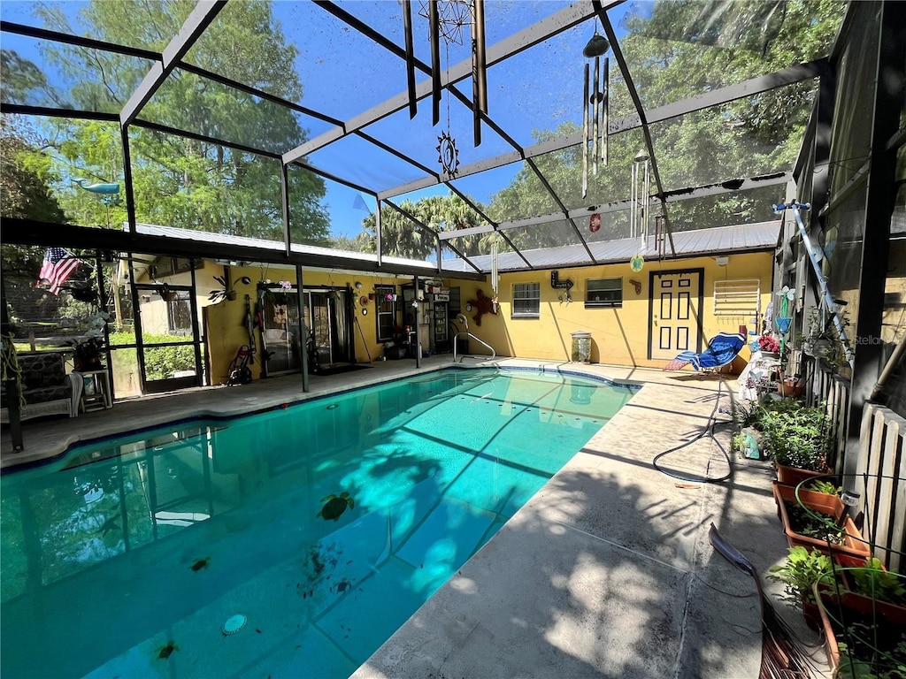 outdoor pool with glass enclosure and a patio area