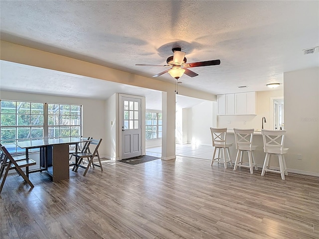 21940 Dupree Dr, Land O Lakes, FL 34639 - living room with ceiling fan, a textured ceiling, baseboards, wood finished floors, and visible vents