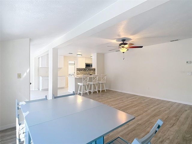 21940 Dupree Dr, Land O Lakes, FL 34639 - dining space featuring visible vents, a ceiling fan, light wood finished floors, and baseboards