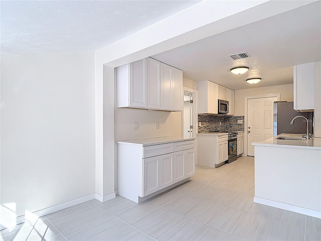 21940 Dupree Dr, Land O Lakes, FL 34639 - kitchen with visible vents, decorative backsplash, light countertops, a sink, and stainless steel appliances