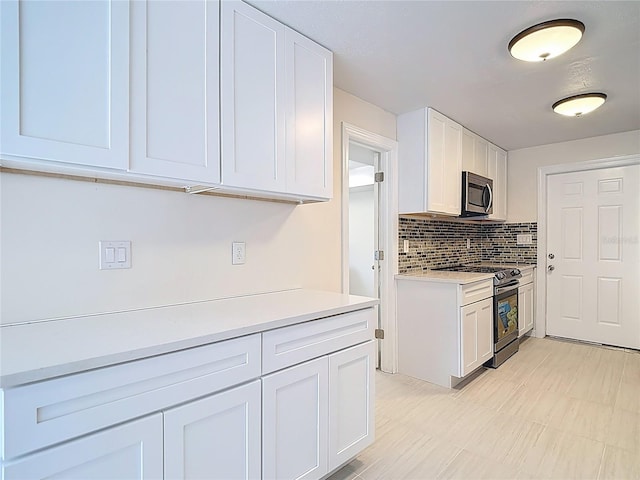 21940 Dupree Dr, Land O Lakes, FL 34639 - kitchen featuring light countertops, white cabinetry, appliances with stainless steel finishes, and decorative backsplash