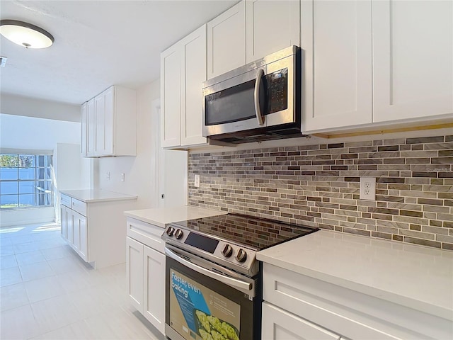 21940 Dupree Dr, Land O Lakes, FL 34639 - kitchen featuring light countertops, appliances with stainless steel finishes, decorative backsplash, and white cabinetry