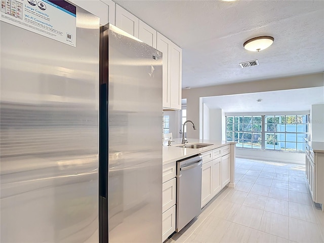 21940 Dupree Dr, Land O Lakes, FL 34639 - kitchen with appliances with stainless steel finishes, a sink, light countertops, white cabinetry, and visible vents