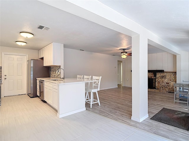 21940 Dupree Dr, Land O Lakes, FL 34639 - kitchen featuring ceiling fan, a breakfast bar area, visible vents, a sink, and stainless steel appliances