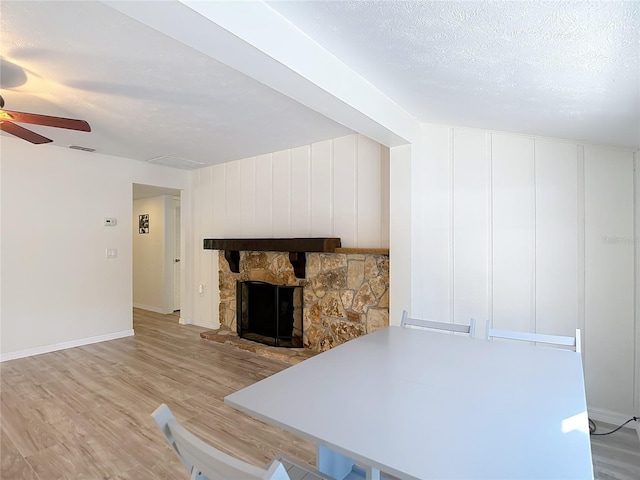 21940 Dupree Dr, Land O Lakes, FL 34639 - unfurnished living room with ceiling fan, a fireplace, light wood-style floors, baseboards, and visible vents