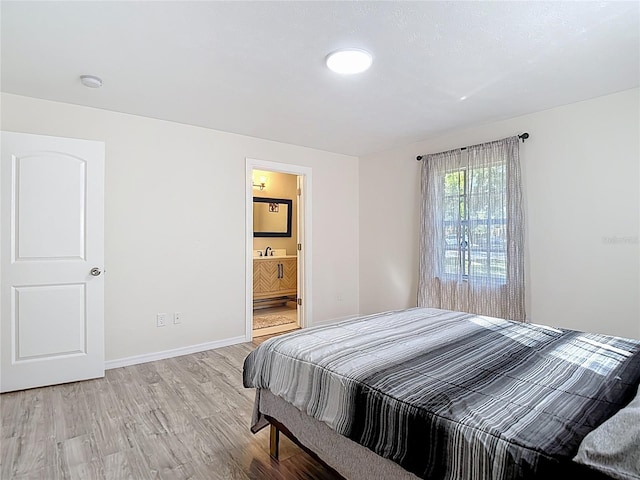 21940 Dupree Dr, Land O Lakes, FL 34639 - bedroom with baseboards, ensuite bath, and light wood-type flooring
