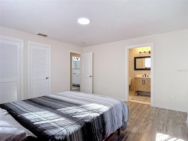 21940 Dupree Dr, Land O Lakes, FL 34639 - bedroom featuring baseboards, visible vents, light wood finished floors, and ensuite bath