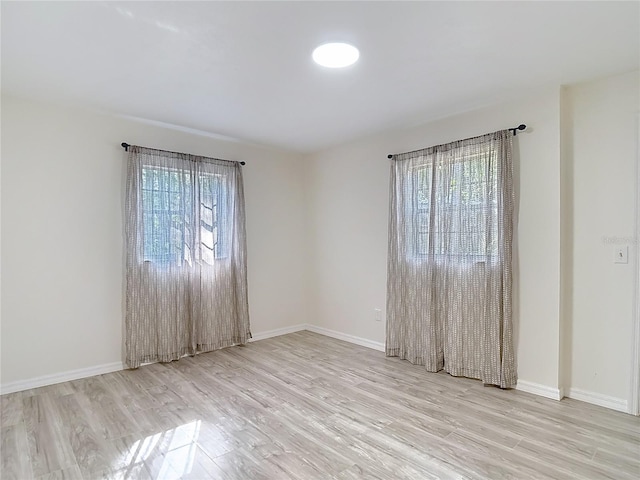 21940 Dupree Dr, Land O Lakes, FL 34639 - unfurnished room with baseboards, plenty of natural light, and wood finished floors