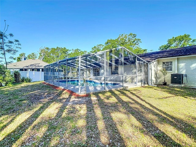 21940 Dupree Dr, Land O Lakes, FL 34639 - back of house featuring fence, a lawn, cooling unit, and an outdoor pool