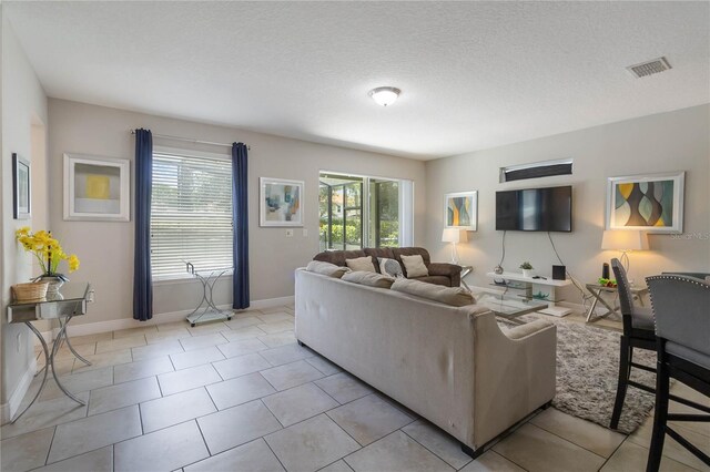 4201 Oakview Dr, Davenport, FL 33837 - living room featuring baseboards, light tile patterned flooring, a textured ceiling, and visible vents