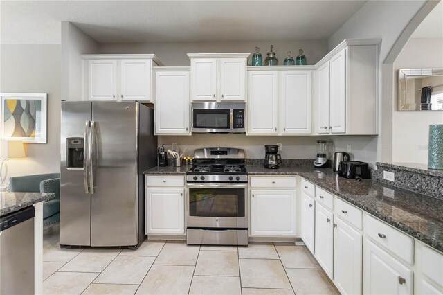 4201 Oakview Dr, Davenport, FL 33837 - kitchen with white cabinetry, dark stone countertops, and stainless steel appliances