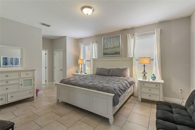 4201 Oakview Dr, Davenport, FL 33837 - bedroom with visible vents, a textured ceiling, baseboards, and light tile patterned floors