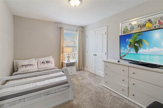 4201 Oakview Dr, Davenport, FL 33837 - bedroom featuring a textured ceiling, light carpet, and a closet