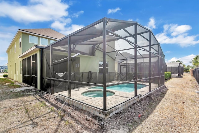 view of pool featuring a patio area, a pool with connected hot tub, and a lanai