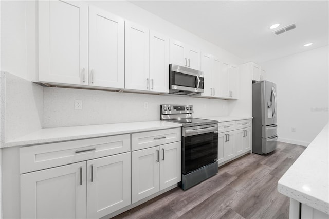 6257 SW 153 Rd Ln, Ocala, FL 34473 - kitchen with white cabinets, stainless steel appliances, visible vents, recessed lighting, and wood finished floors