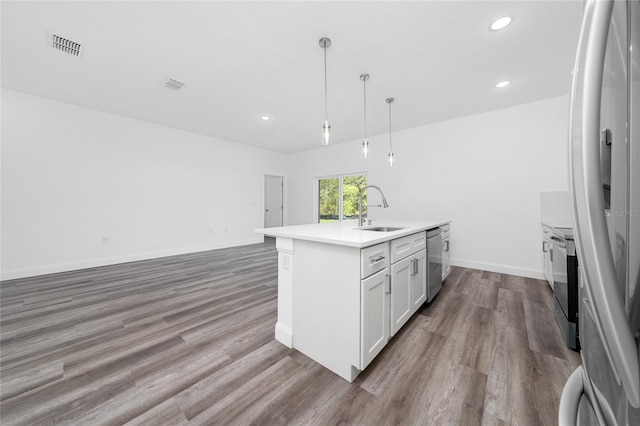 6257 SW 153 Rd Ln, Ocala, FL 34473 - kitchen with a kitchen island with sink, a sink, visible vents, wood finished floors, and appliances with stainless steel finishes