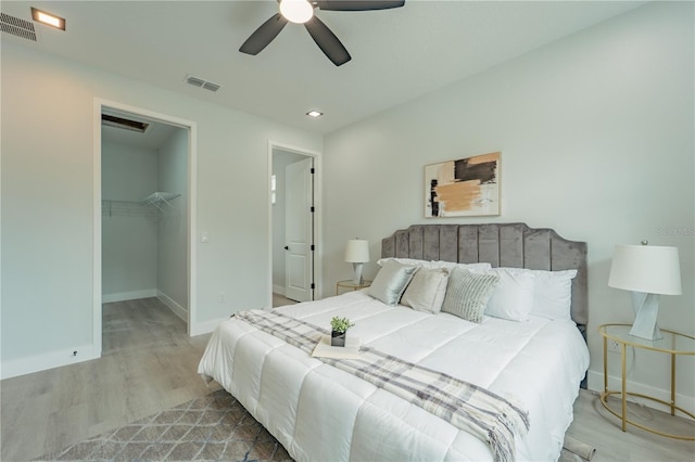 59 W 10th St, Apopka, FL 32703 - bedroom featuring wood finished floors, a walk in closet, a ceiling fan, and a closet