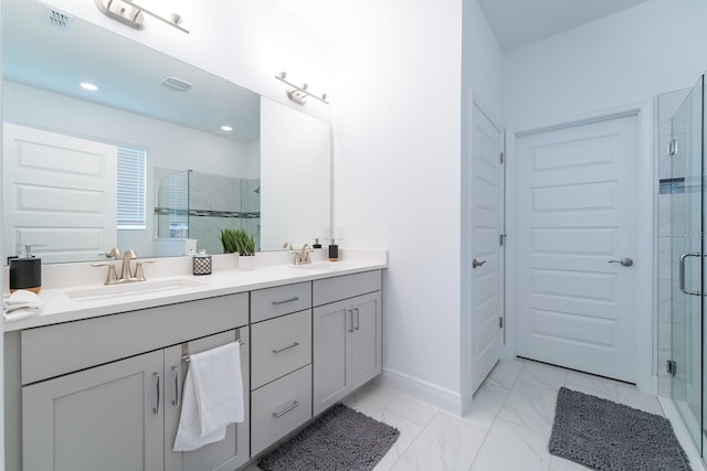 bathroom with double vanity, a shower stall, marble finish floor, and a sink