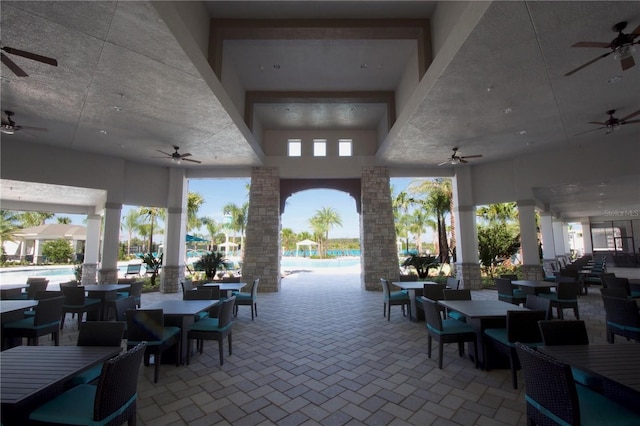 view of patio featuring a ceiling fan, a community pool, and outdoor dining space
