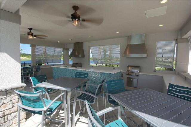 view of patio / terrace with grilling area, an outdoor kitchen, outdoor dining space, and a ceiling fan