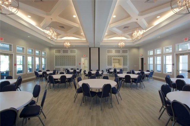 dining area featuring coffered ceiling, a chandelier, light wood finished floors, and baseboards