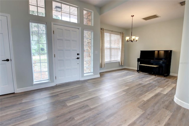 entrance foyer featuring visible vents, a notable chandelier, and a healthy amount of sunlight
