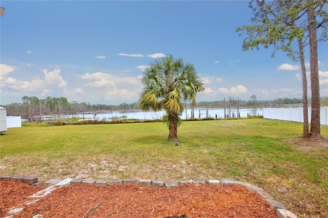 view of yard with fence and a water view