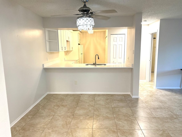 604 Kenwick Cir Unit 105, Casselberry, FL 32707 - kitchen with a sink, a textured ceiling, ceiling fan, light countertops, and a peninsula