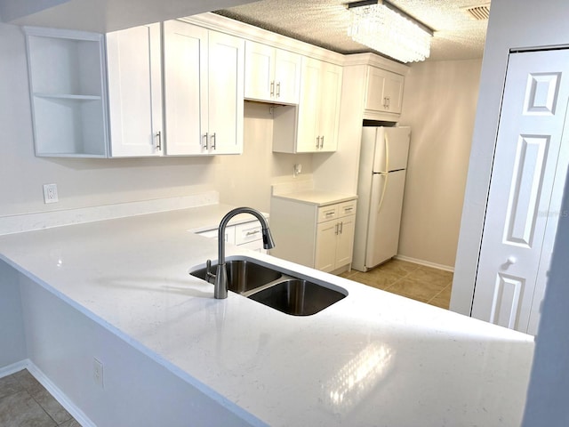 604 Kenwick Cir Unit 105, Casselberry, FL 32707 - kitchen featuring a sink, freestanding refrigerator, light stone counters, open shelves, and light tile patterned floors