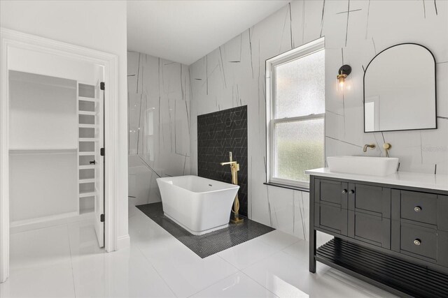 16500 Magnolia Terrace Blvd, Montverde, FL 34756 - full bath featuring tile walls, a freestanding tub, vanity, a spacious closet, and tile patterned floors