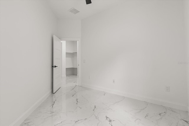 16500 Magnolia Terrace Blvd, Montverde, FL 34756 - unfurnished bedroom with light marble finish floors, baseboards, a ceiling fan, and a walk in closet