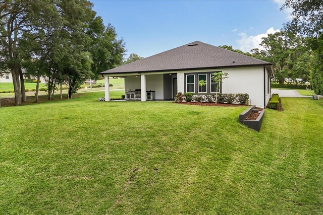 16500 Magnolia Terrace Blvd, Montverde, FL 34756 - back of house featuring a yard, a shingled roof, and stucco siding