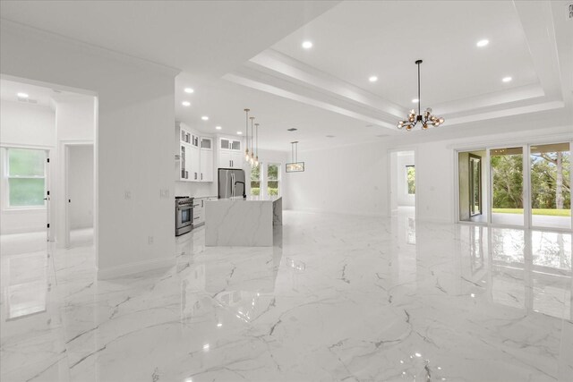 16500 Magnolia Terrace Blvd, Montverde, FL 34756 - unfurnished living room with a chandelier, recessed lighting, a tray ceiling, light marble finish flooring, and ornamental molding