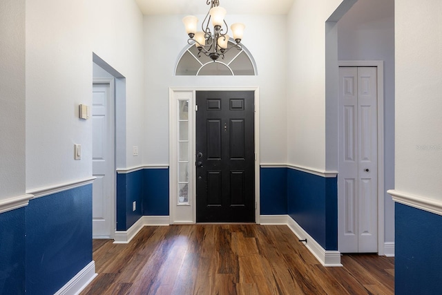 foyer entrance with baseboards, a notable chandelier, and wood finished floors