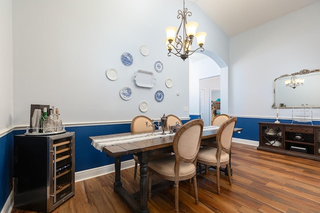 dining area featuring arched walkways, lofted ceiling, wood finished floors, and a chandelier
