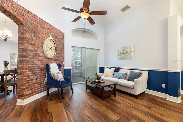 living area featuring baseboards, visible vents, wood finished floors, and high vaulted ceiling