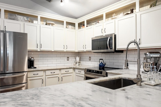kitchen with white cabinets, open shelves, stainless steel appliances, and backsplash