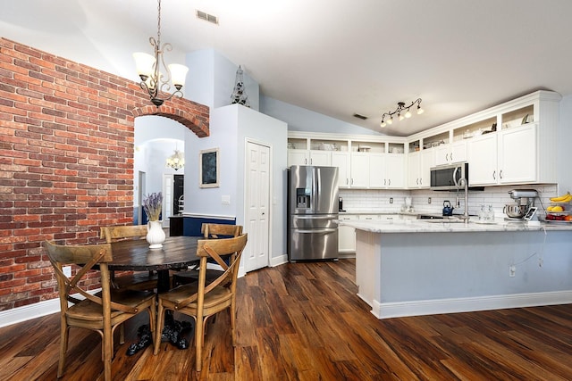 kitchen featuring a notable chandelier, appliances with stainless steel finishes, visible vents, a peninsula, and vaulted ceiling