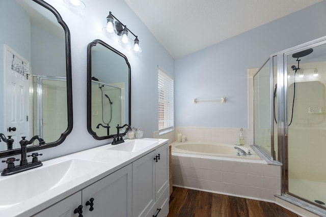 full bathroom featuring a sink, a garden tub, a stall shower, and wood finished floors